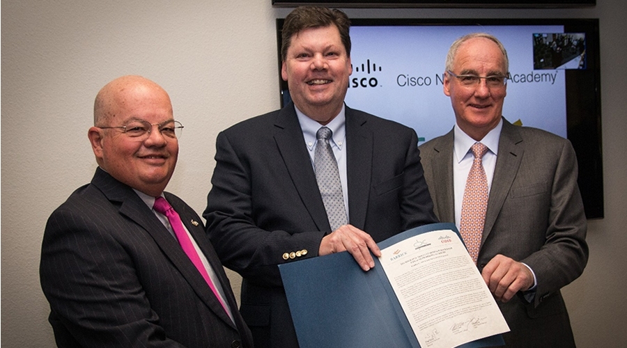 Great Basin College president Dr. Mark Curtis, from left, Cisco corporate social responsibility manager John Bjerke and Barrick USA executive director Nigel Bain pose with the signed collaborative learning agreement of the Networking Academy at the High Tech Career Center at Great Basin College in Elko on Thursday, April 20, 2017. 