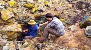 Jay Stephens (right) collects samples of copper ore from a mine in Africa.