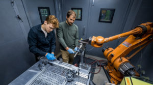 Graduate students set up equipment to apply a coating via cold spray in Professor Kumar Sridharan’s Cold Spray Laboratory.