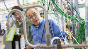 Researchers Shin Young Jeong and Zhiwen Ma examine the prototype device that uses superheated sand for long-duration energy storage